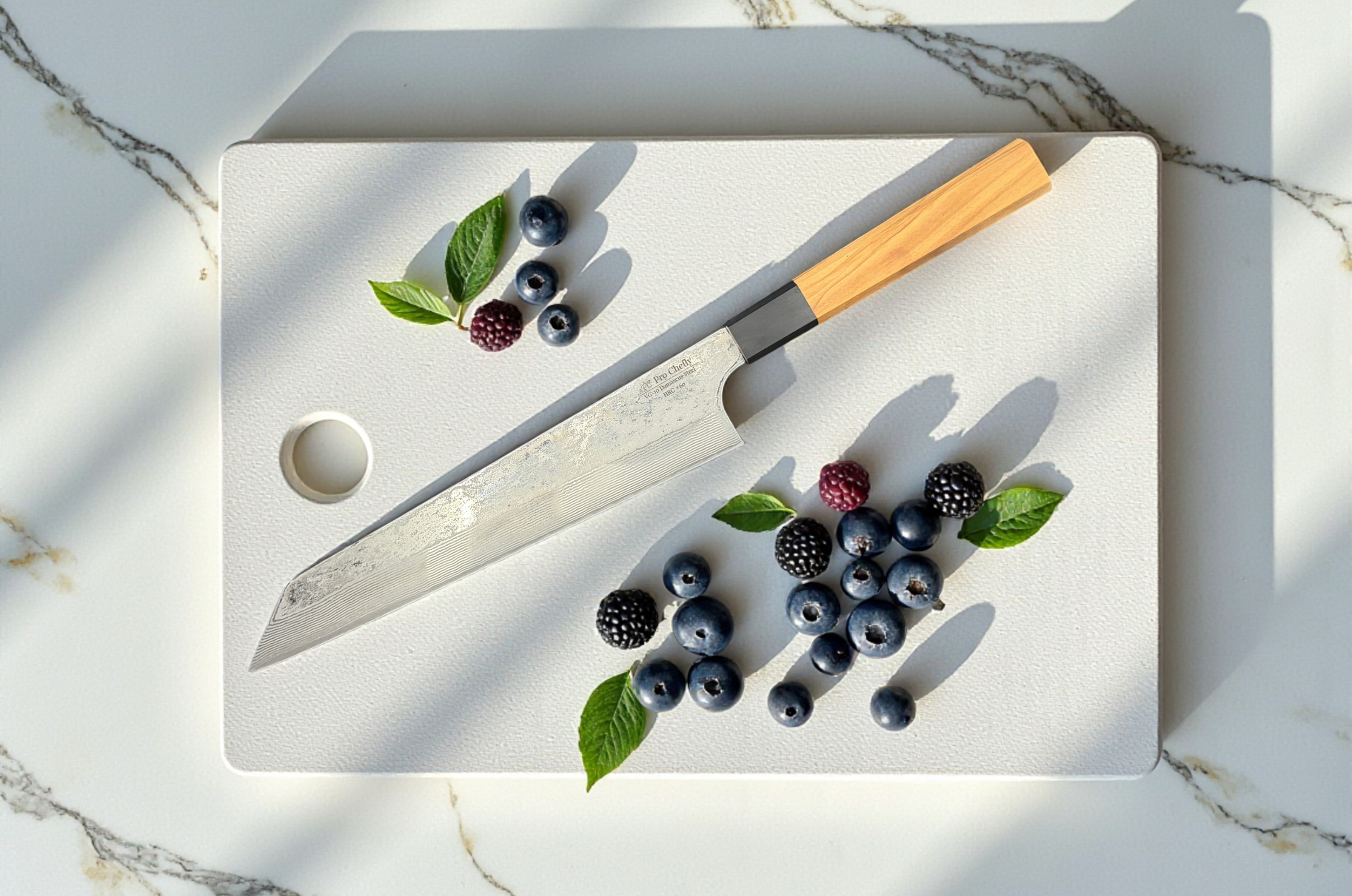 Image of Pro Chefly Kiritsuke knife displayed on a cutting board with fresh blueberries, blackberries, raspberries, and mint leaves.