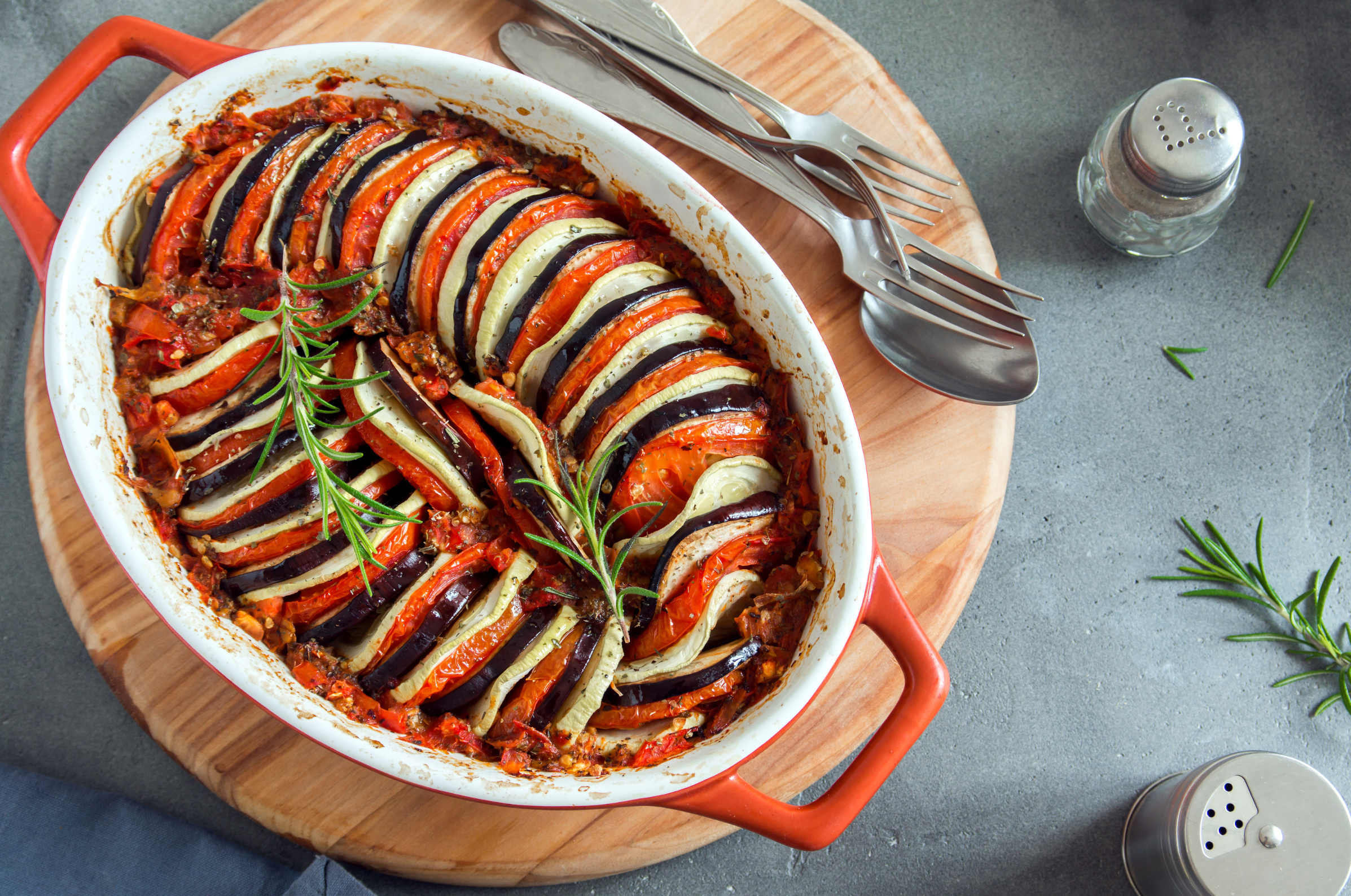 Image of Pro Chefly classic ratatouille baked with eggplant, zucchini, tomatoes, onions, and fresh rosemary in a casserole dish.