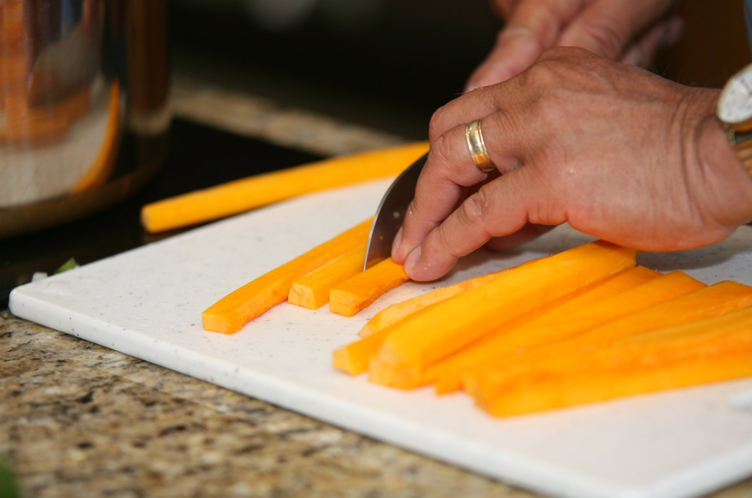 Image of Pro Chefly Damascus knife slicing fresh carrots on a cutting board, showcasing precise cuts, sharp control, and everyday kitchen craftsmanship.