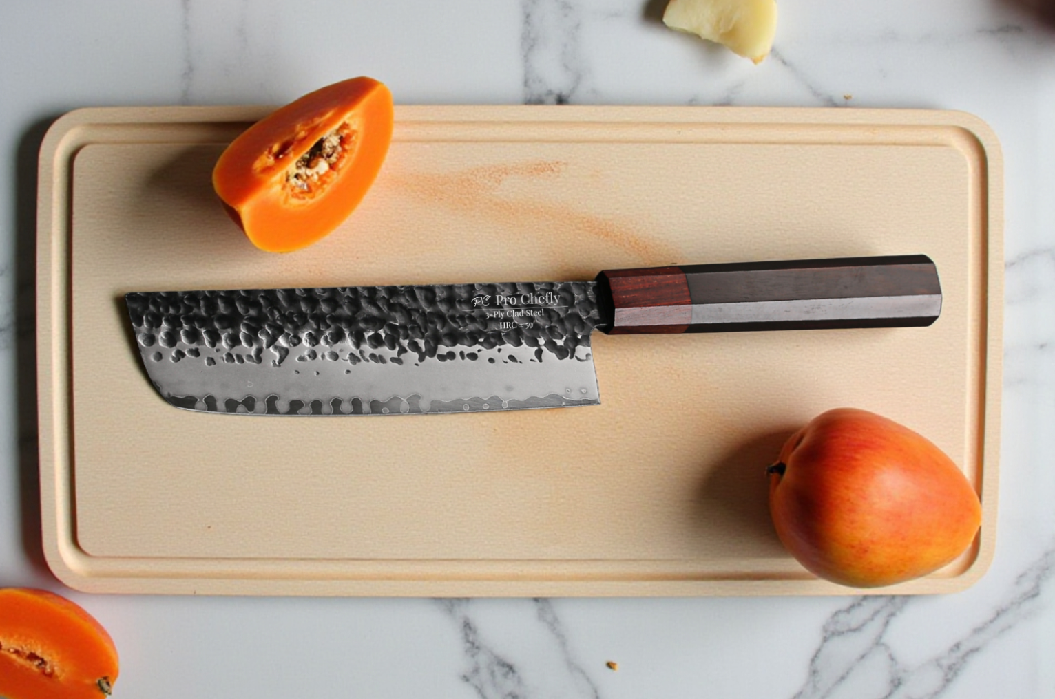 Image of Pro Chefly Japanese Damascus nakiri knife with a hammered blade resting on a cutting board, styled with fresh papaya and apple on a marble surface.