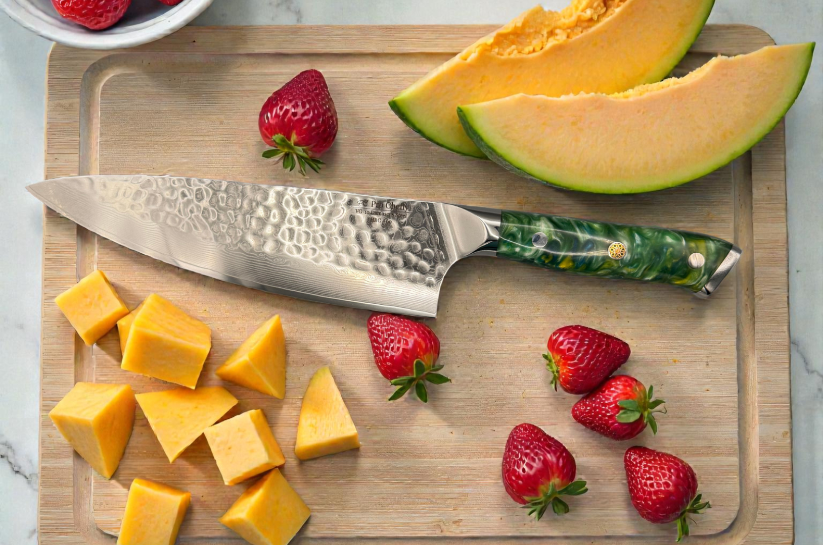 Image of Pro Chefly VG-10 Damascus chef knife with hammered finish and green resin handle displayed on a wooden cutting board with fresh cantaloupe slices and strawberries.