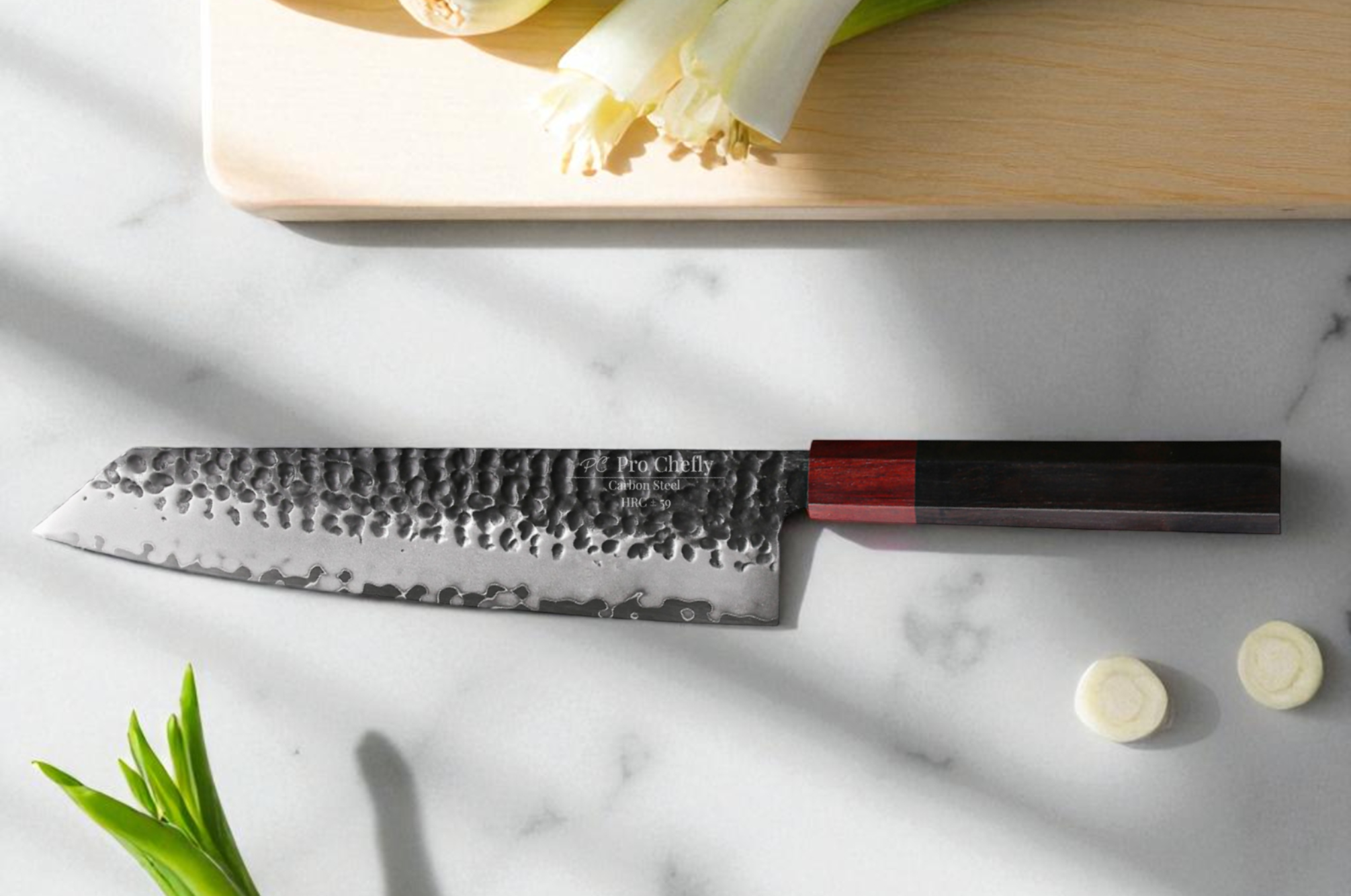 Image of Pro Chefly hammered Kiritsuke Japanese knife on a marble surface with fresh green onions and a wooden cutting board.