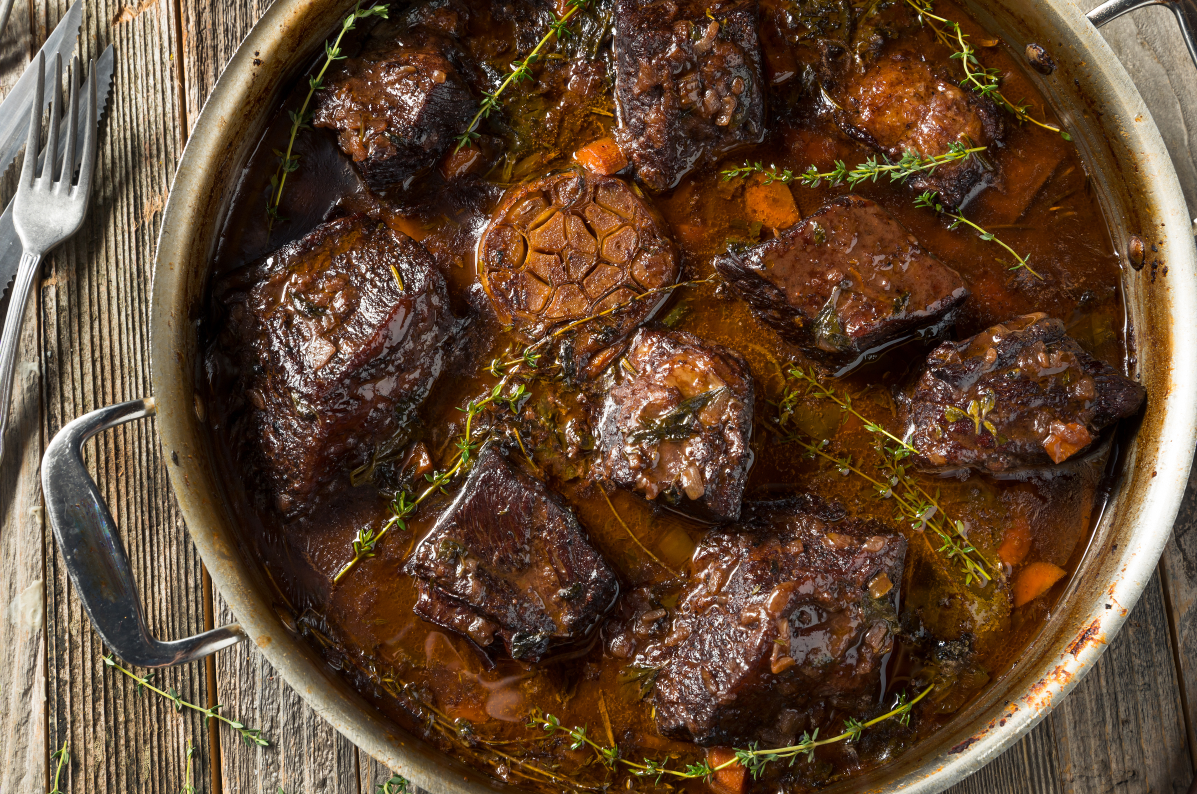 ChatGPT said:  Pro Chefly braised short ribs simmering in rich sauce with garlic and thyme, showcasing hearty, slow-cooked winter comfort food.