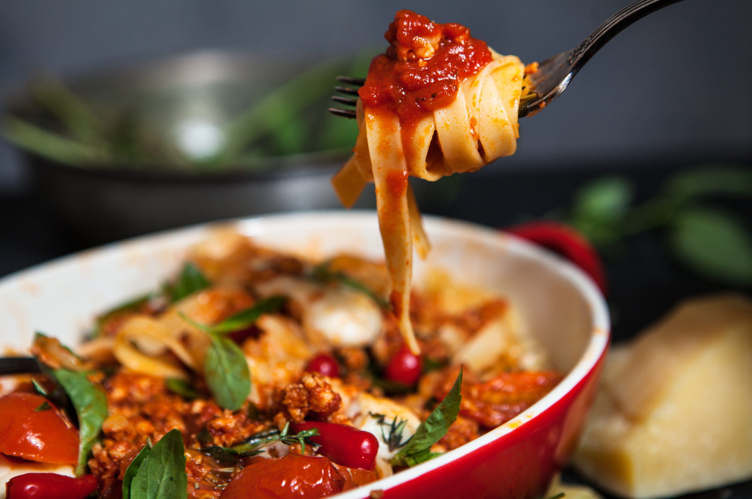 Image of Pro Chefly pappardelle pasta twirled on a fork with rich tomato meat sauce, fresh herbs, and Parmesan, showcasing bold texture, hearty flavor, and rustic Italian comfort food presentation