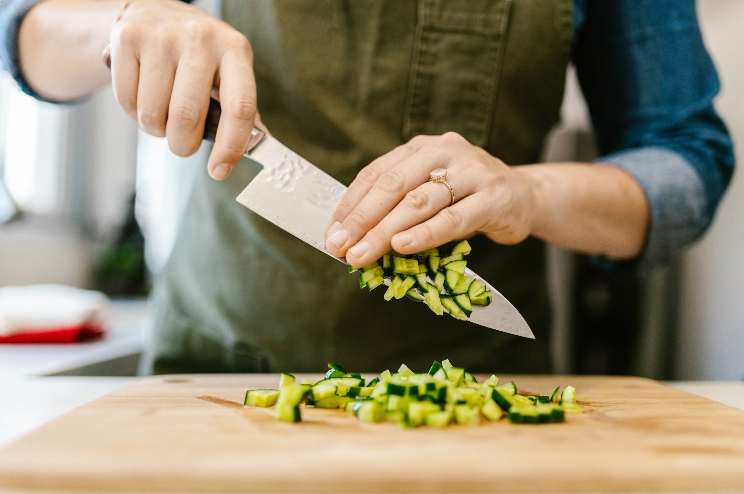 Image of Pro Chefly Japanese Damascus chef knife dicing fresh zucchini on a wooden cutting board, showcasing precise cuts and effortless kitchen prep