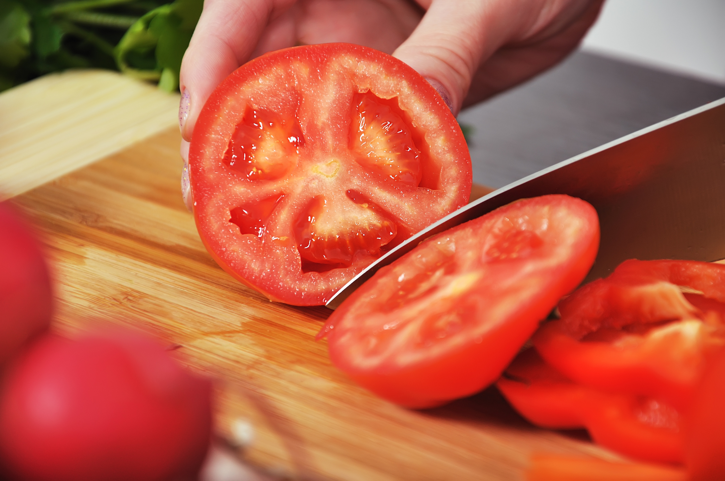 Pro Chefly knife slicing a ripe tomato on a cutting board, highlighting clean cuts and precise kitchen performance.