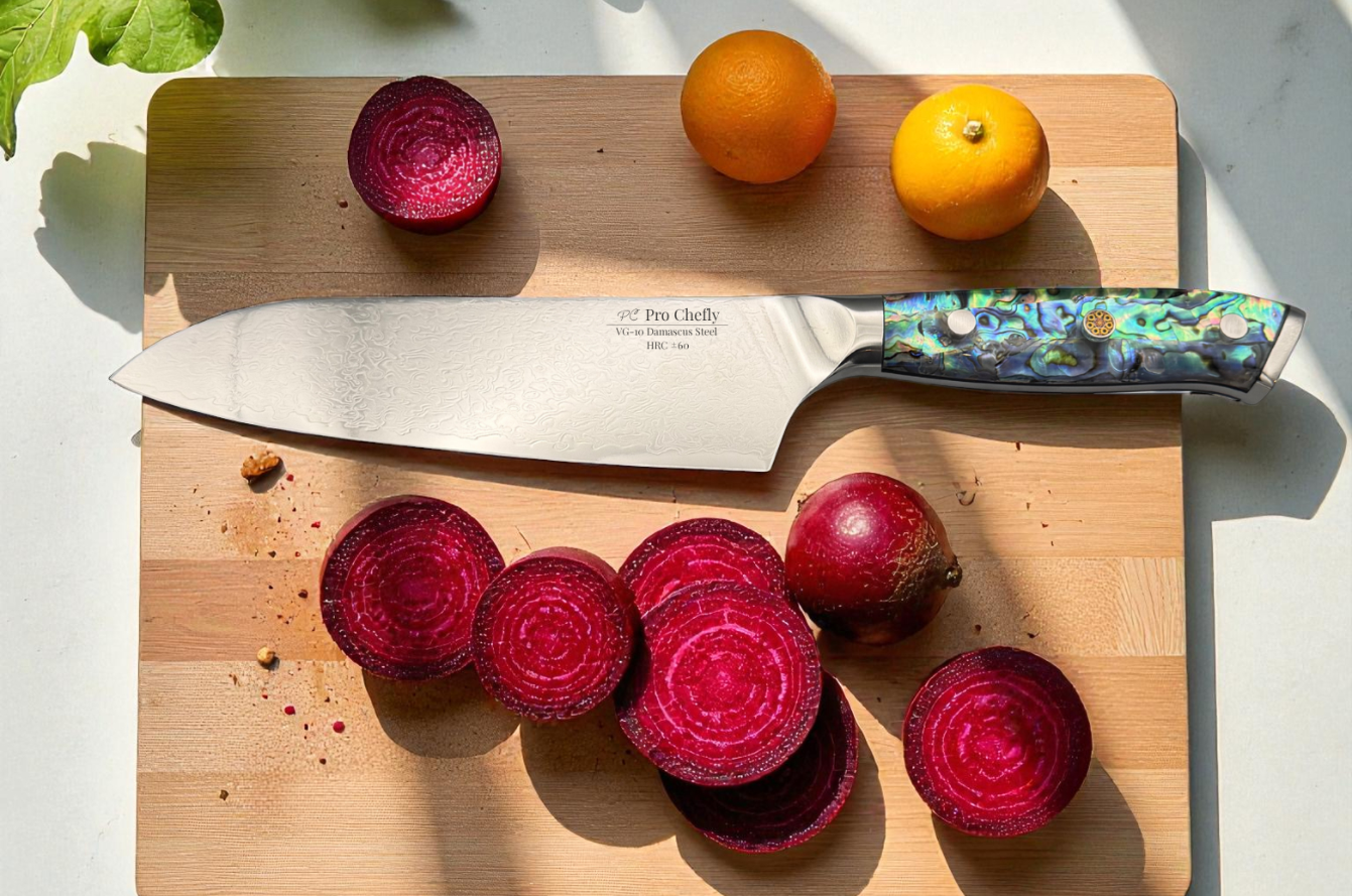 Image of Pro Chefly Damascus chef knife resting on a wooden cutting board with freshly sliced red beets and citrus, showcasing Japanese VG-10 Damascus steel