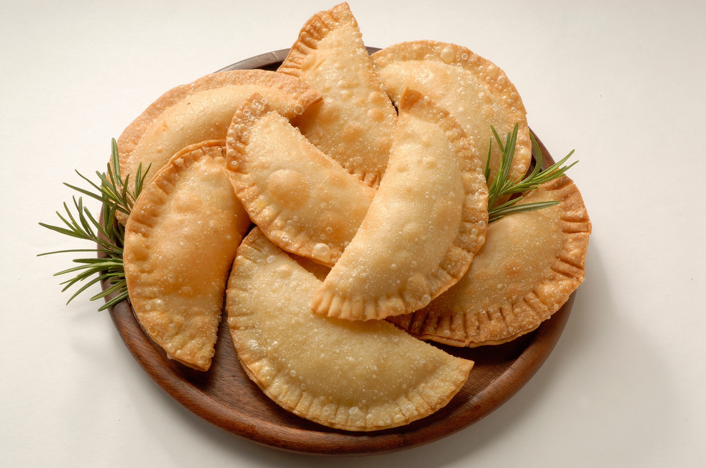Image of Pro Chefly Dominican beef empanadas with crispy golden pastry shells served on a wooden platter, authentic Caribbean comfort food.