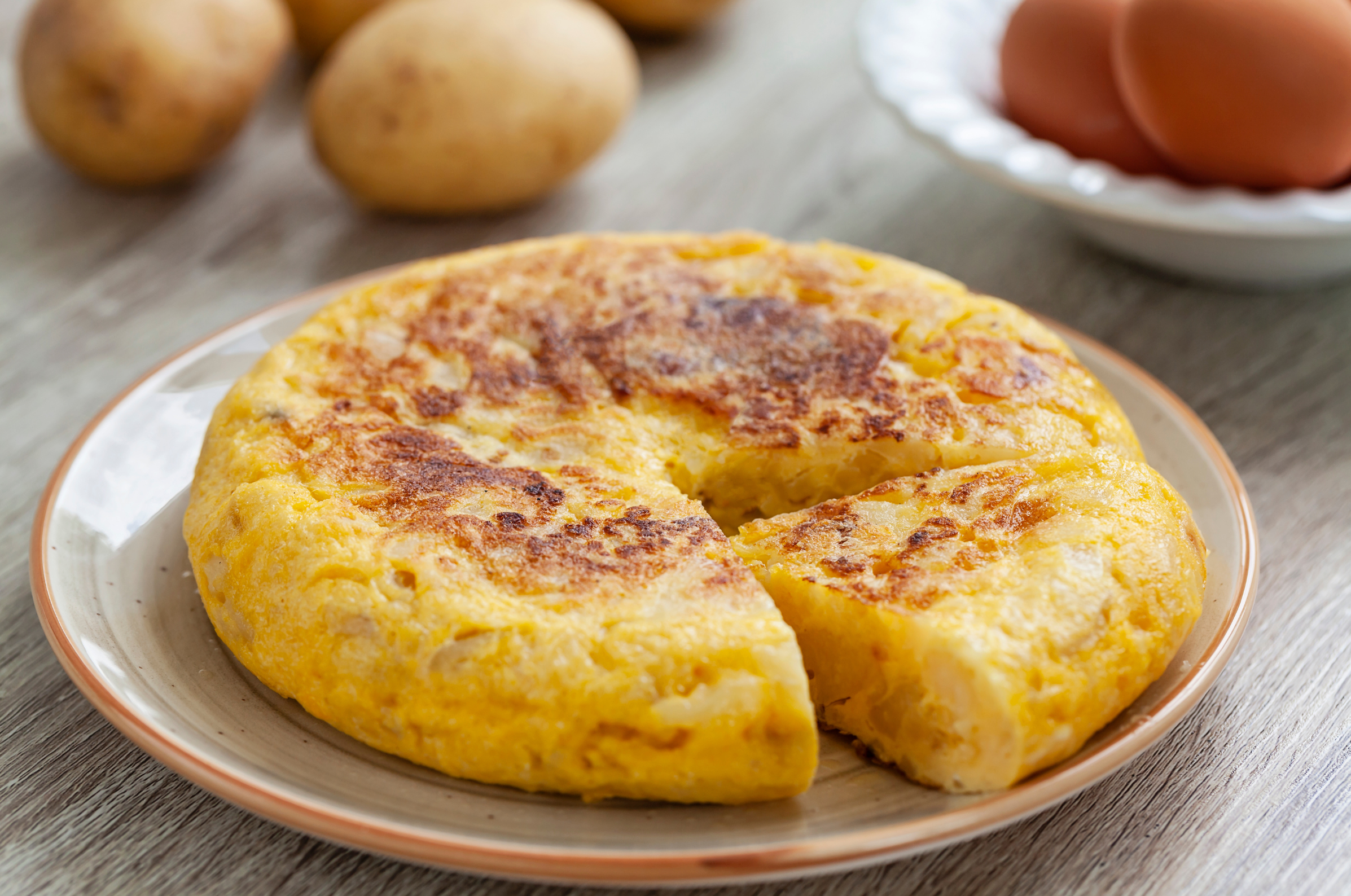 Image of Pro Chefly Spanish tortilla with golden potatoes and eggs, pan-cooked until crisp on the outside and tender in the center.