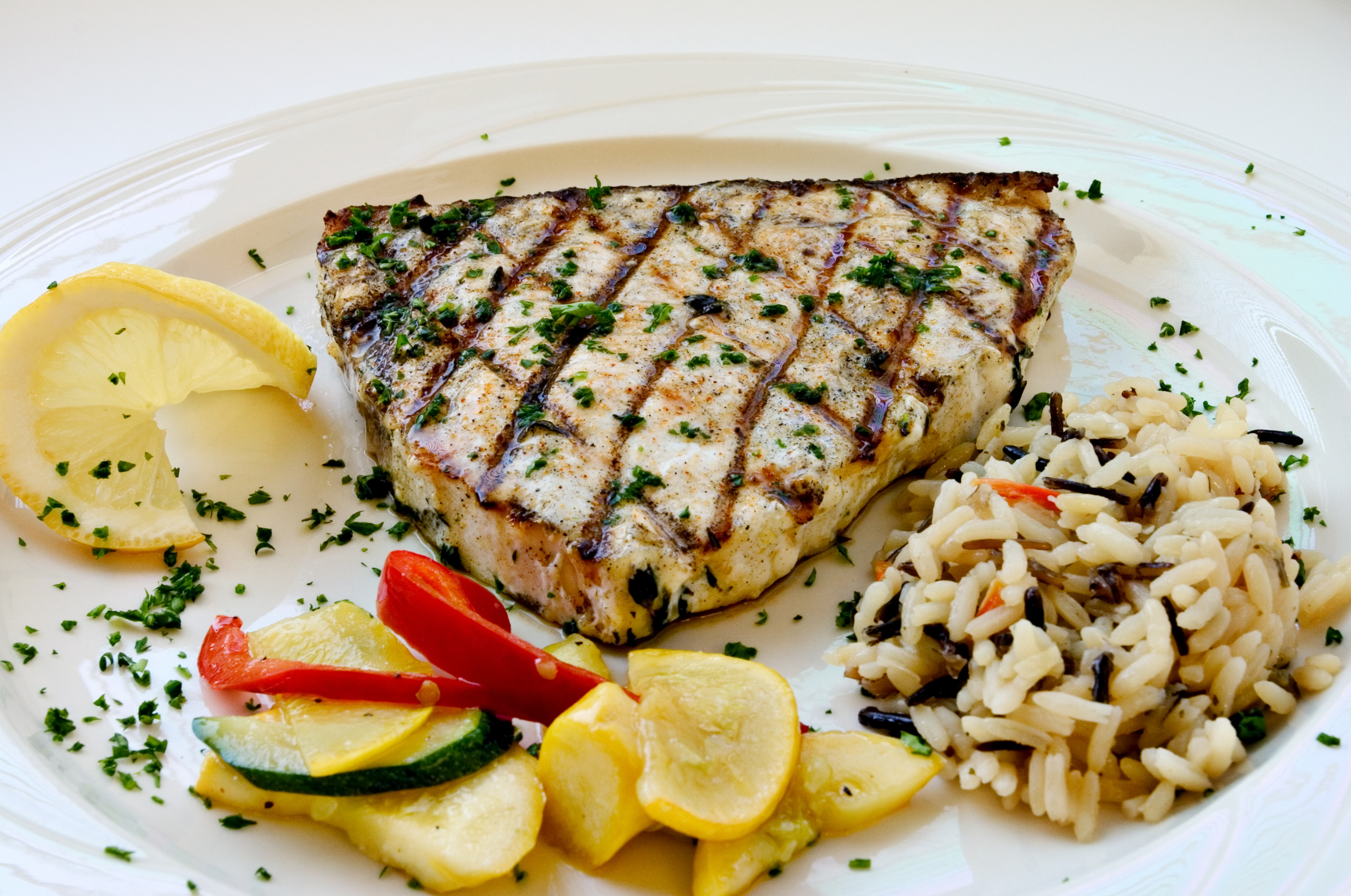 Image of Pro Chefly grilled swordfish served with wild rice, sautéed squash, peppers, and fresh lemon for a light, flavorful seafood dinner.