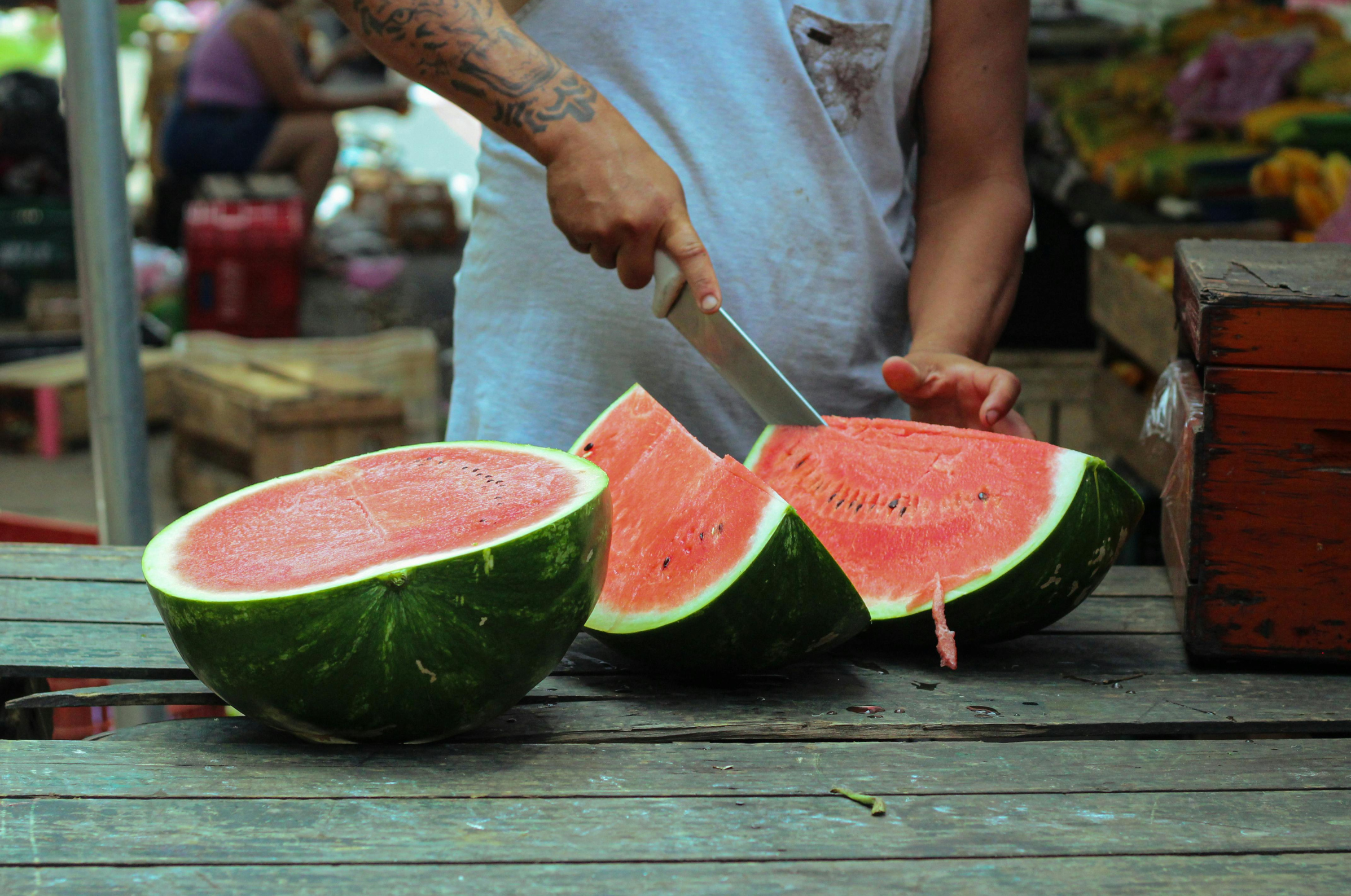 Image of Pro Chefly chef slicing fresh watermelon with a Damascus kiritsuke knife, showcasing precision knife skills and summer fruit preparation.