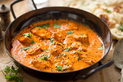 Image of Authentic Indian butter chicken served with basmati rice, naan, and raita in white bowls, garnished with fresh cilantro – Pro Chefly.