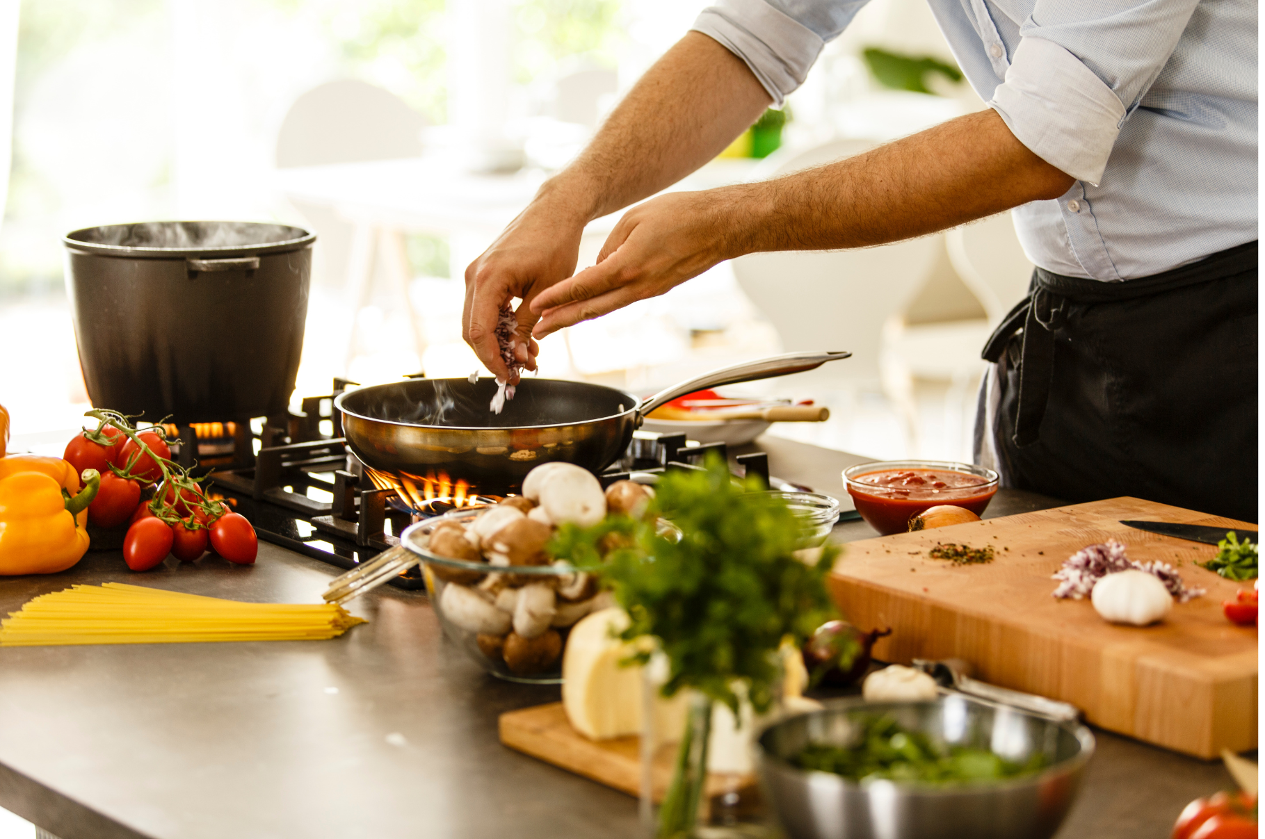 Chef cooking pasta sauce with fresh vegetables and herbs, ingredients prepped using a Pro Chefly chef knife for precise cuts and professional results.