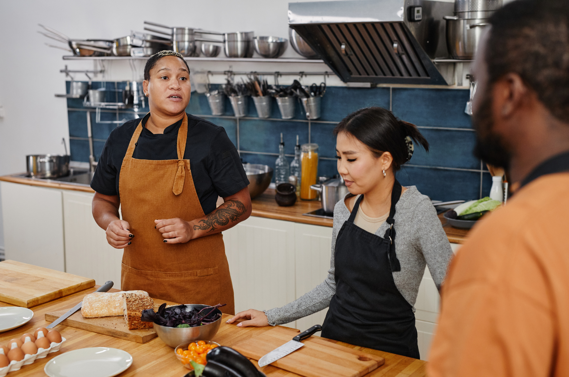 Chefs in a professional kitchen preparing ingredients with a Pro Chefly Santoku knife on the cutting board, showcasing precision and versatility for everyday cooking.