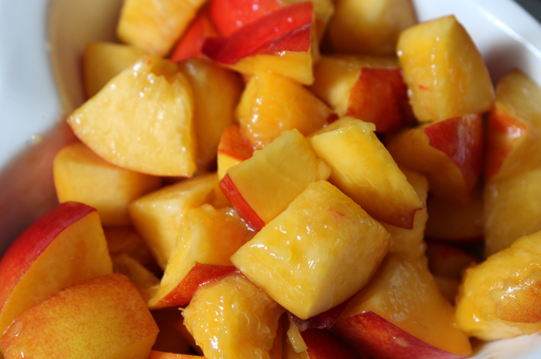 Fresh peaches sliced into bite-sized pieces using Pro Chefly petty and paring knives, highlighting precision cutting for fruit prep in home kitchens.