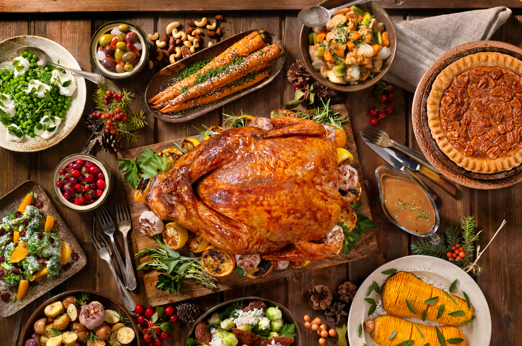 Beautifully arranged Thanksgiving dinner spread featuring a golden roasted turkey, vegetables, sides, and pecan pie, styled for Pro Chefly and prepared using Damascus kitchen knives.