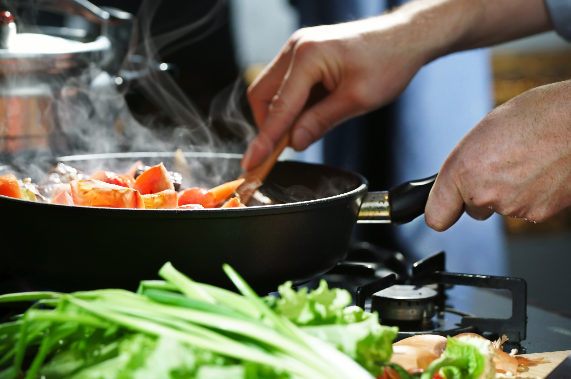 Chef sautéing fresh vegetables in a steaming pan over open flame — a dynamic cooking moment that highlights Pro Chefly’s precision tools and passion for handcrafted meals.