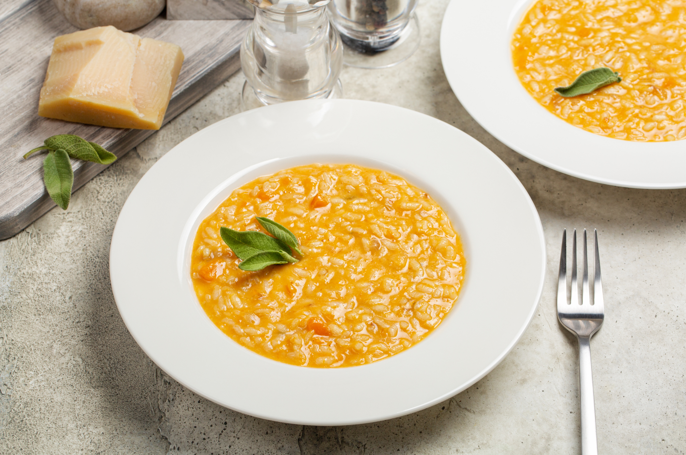 Image of pro chefly creamy pumpkin risotto garnished with fresh sage, showcasing seasonal flavor and elegant plating