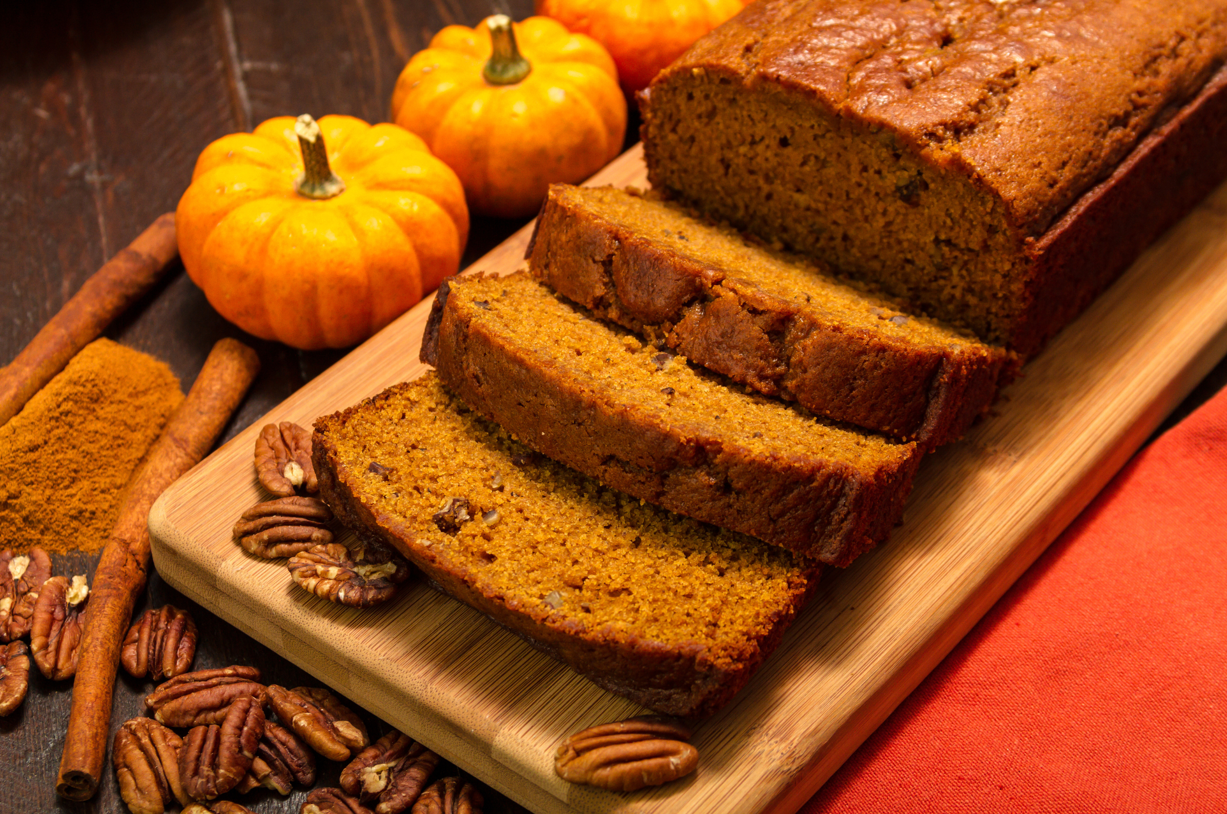 Image of warm spiced pumpkin bread with pecans on a wooden board, styled for Pro Chefly with rich autumn tones, showcasing cozy seasonal baking perfection and handcrafted presentation