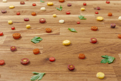 Image of Colorful carrot slices and parsley leaves scattered on a wooden surface — perfect prep work with a Pro Chefly petty knife.