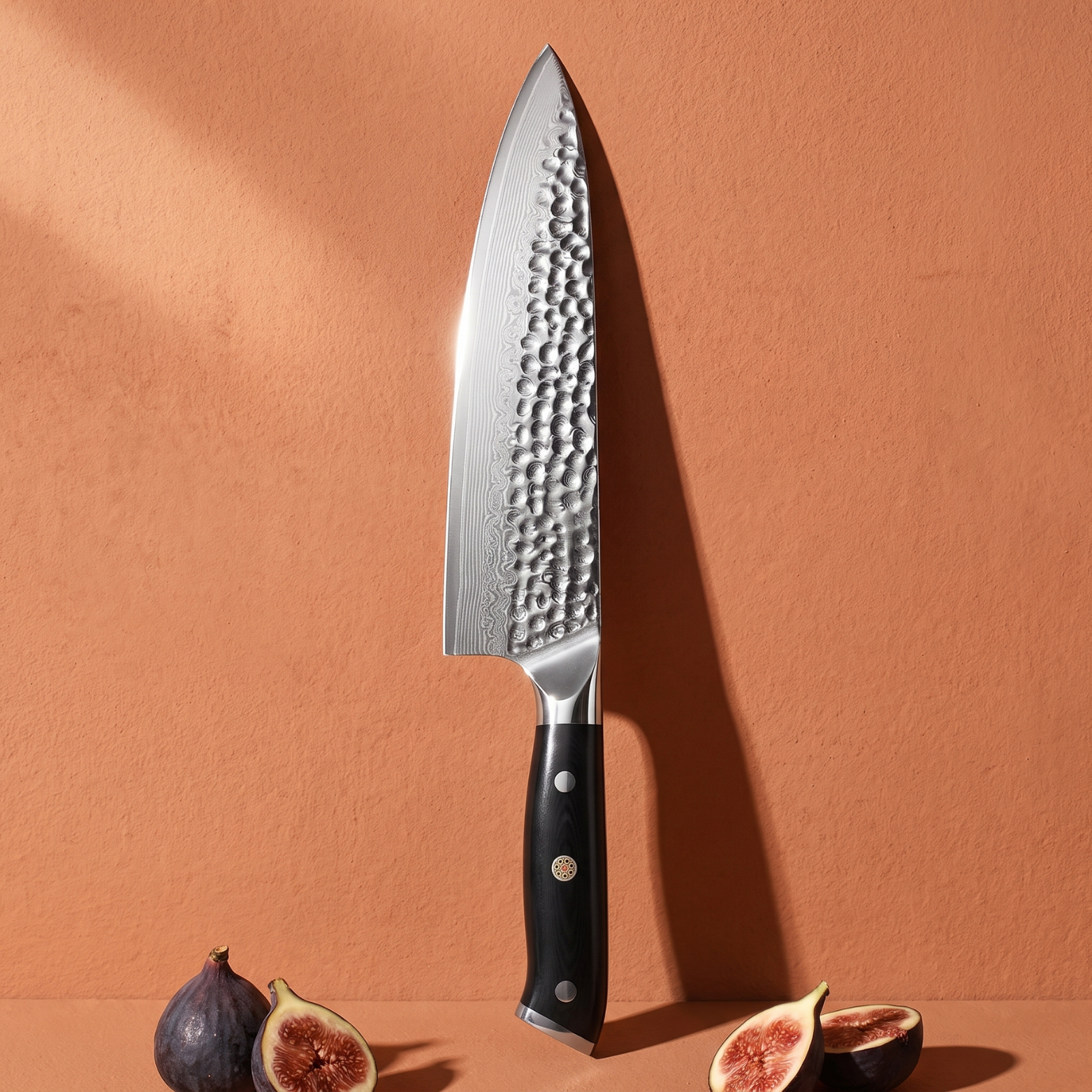 Image of Pro Chefly 8-inch Damascus chef knife with black triple-riveted handle, standing against a terracotta wall with fresh figs