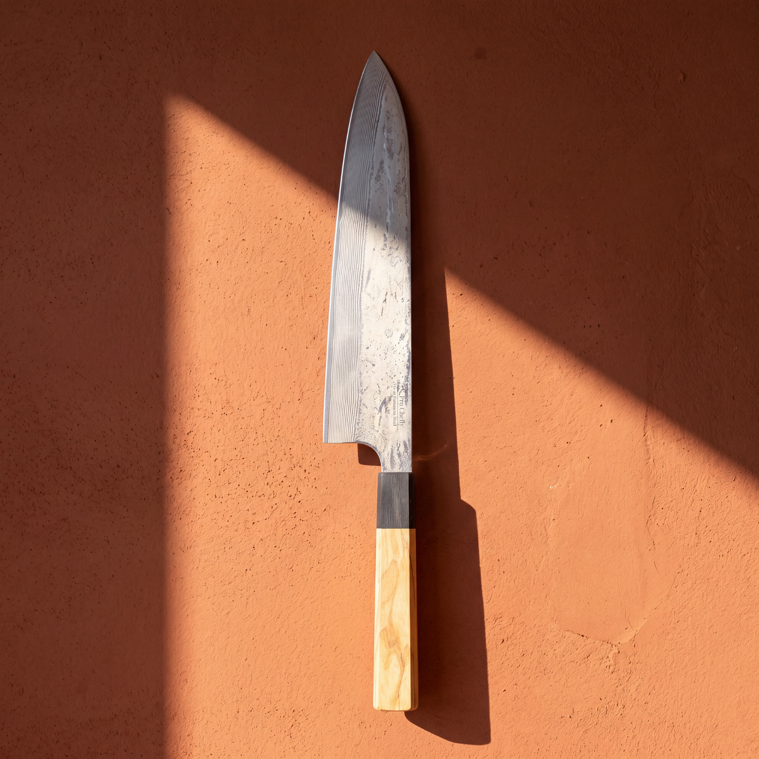 Image of Pro Chefly 9-inch Damascus gyuto chef knife with olivewood wa handle, standing against a terracotta wall