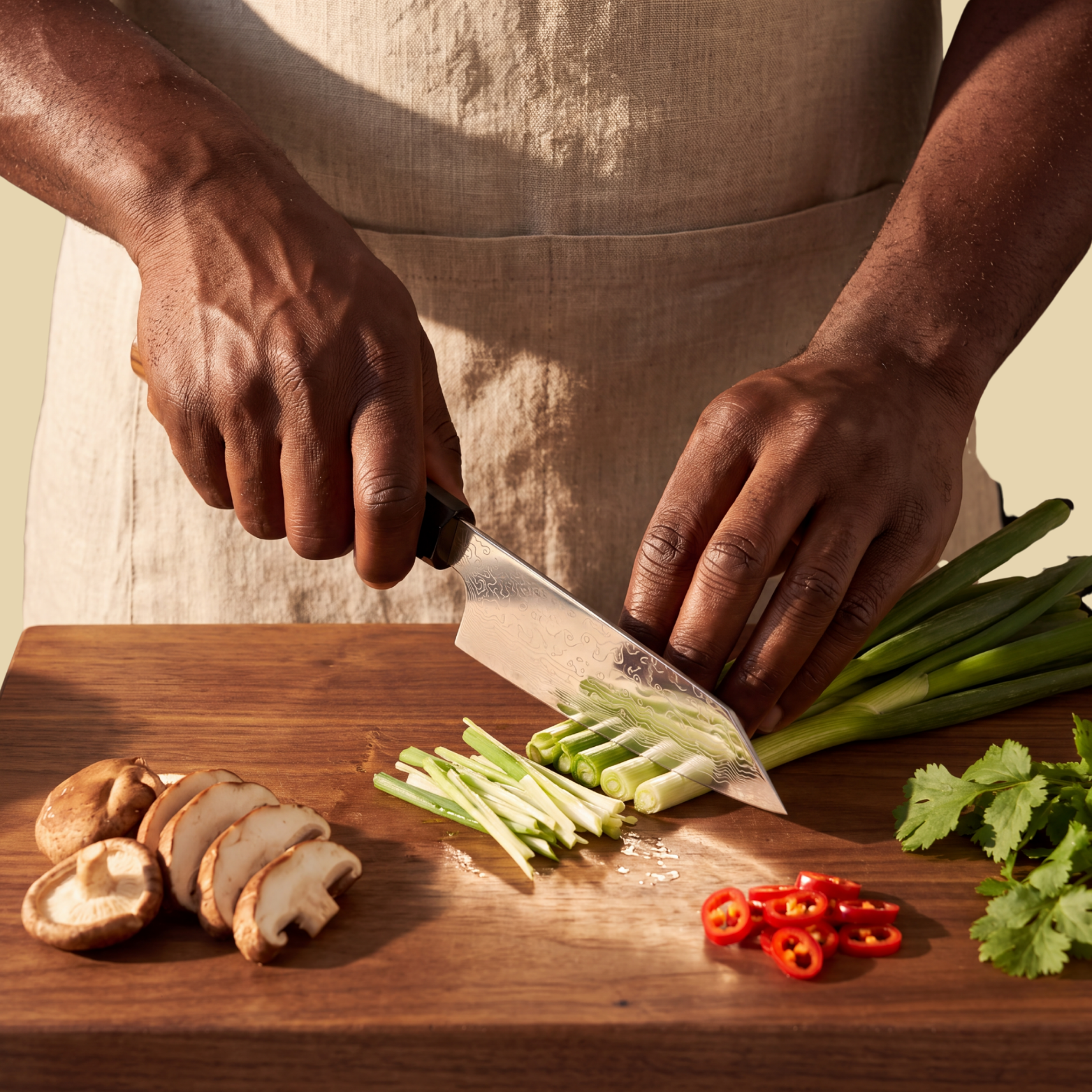 Image of Pro Chefly 5-inch Damascus mini bunka knife slicing scallions on a walnut board with shiitake and red chili