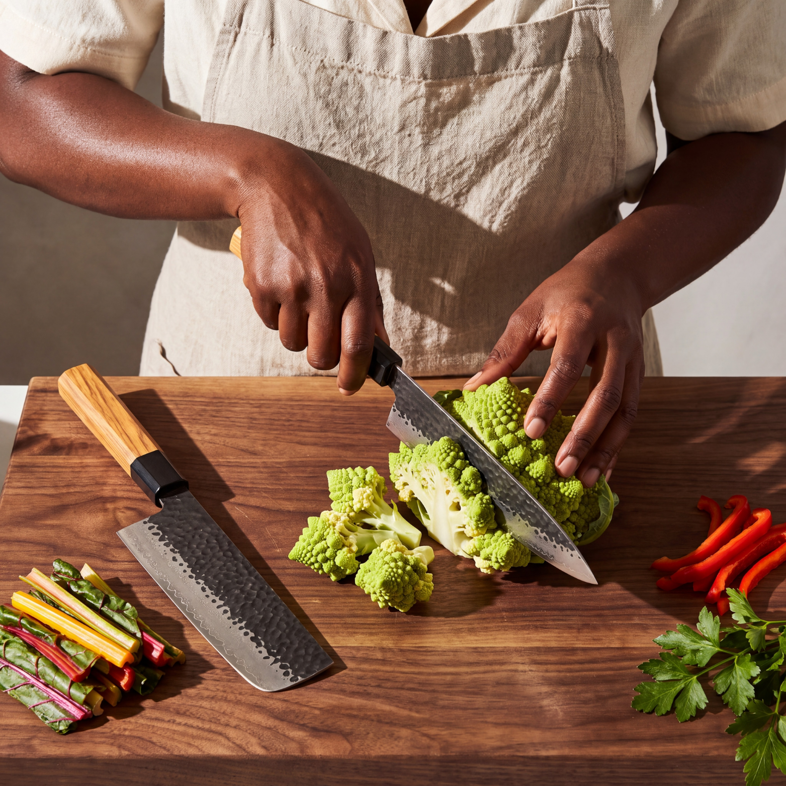 Image of Pro Chefly 2-piece Damascus knife set with olivewood wa handles, cutting romanesco on a walnut board