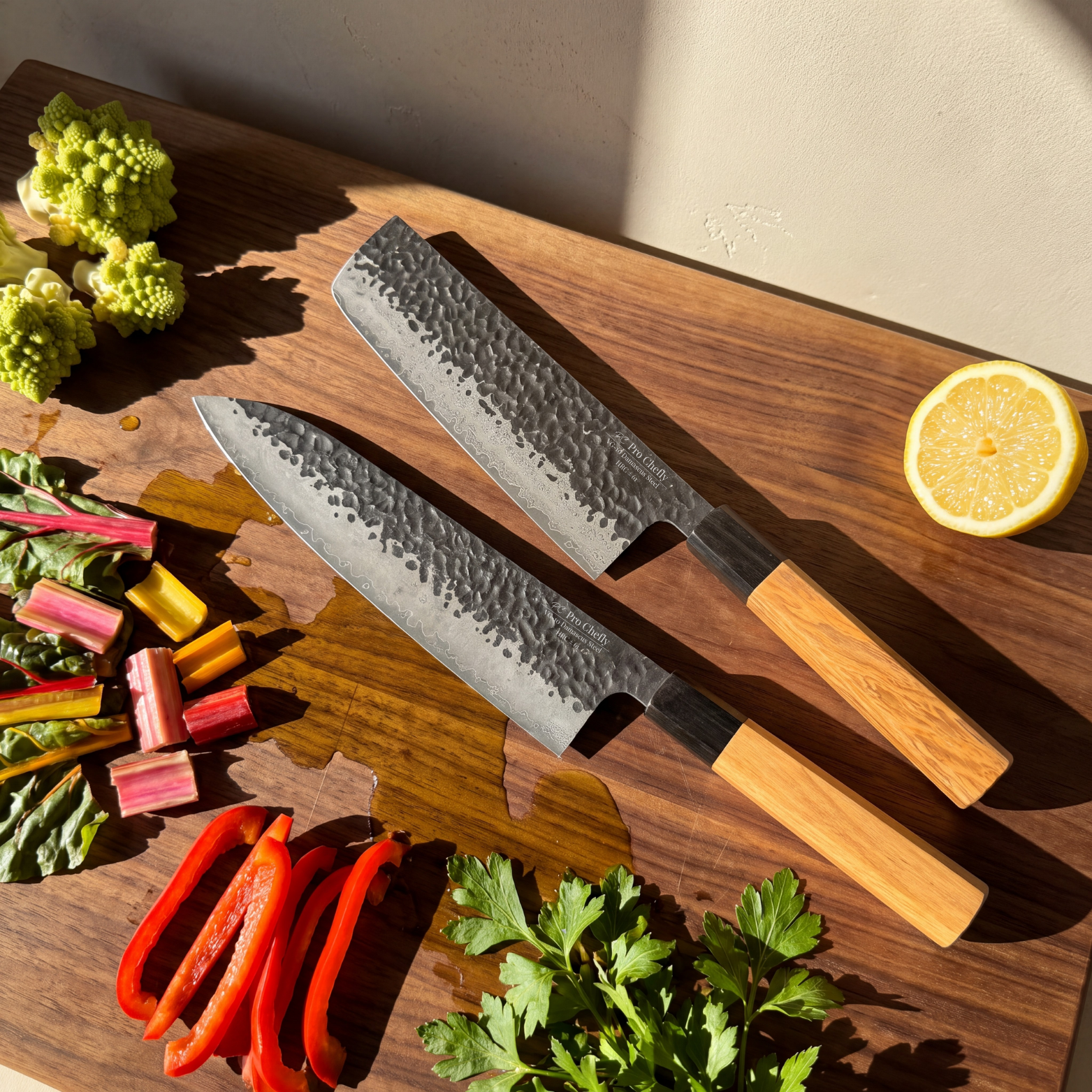Image of Pro Chefly 2-piece Damascus knife set with olivewood wa handles, overhead with rainbow chard, red pepper and lemon