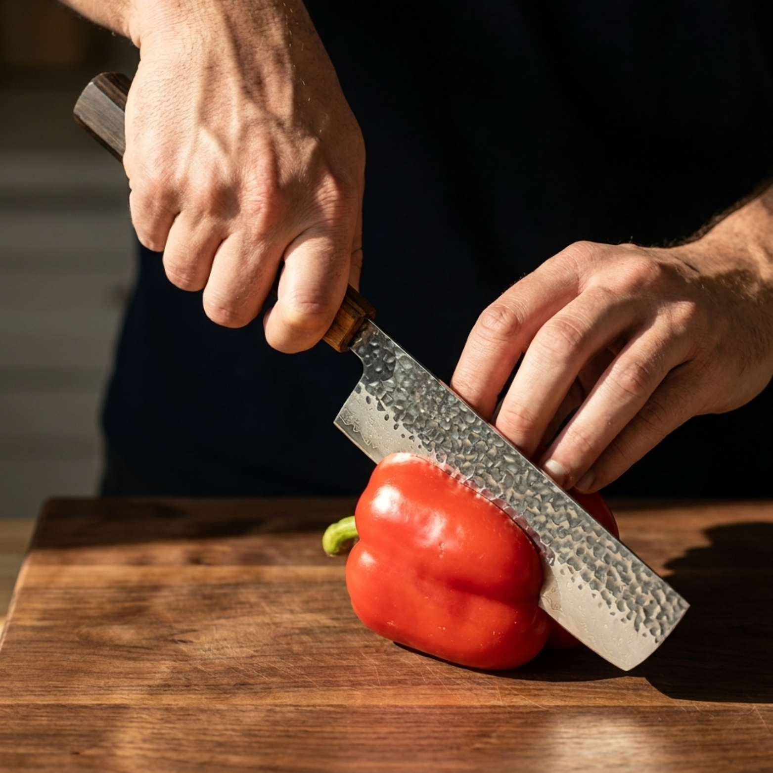 Image of Pro Chefly 3-piece Damascus knife set with black-and-amber pakkawood wa handle, halving a red bell pepper on a walnut board