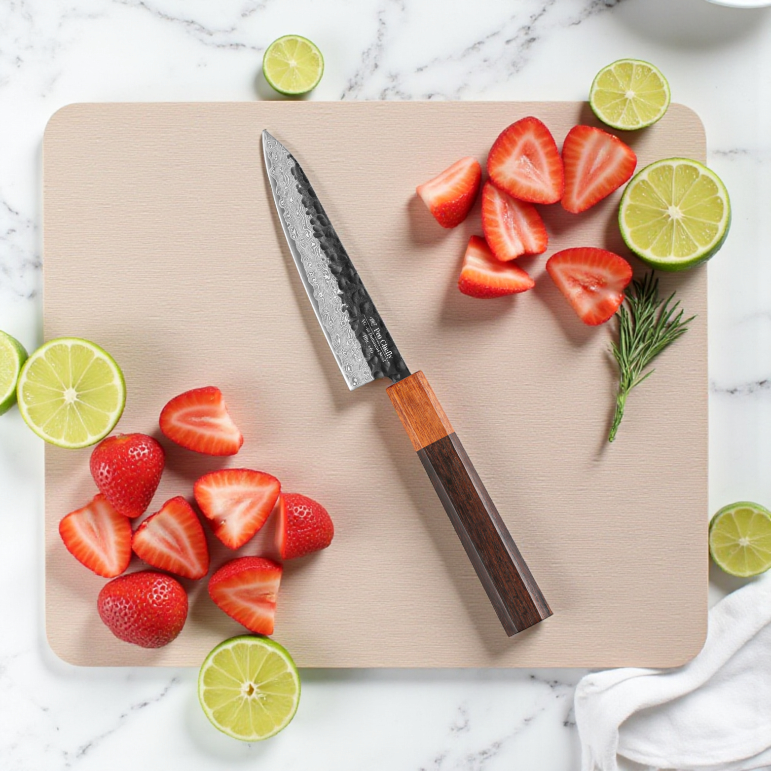 Image of Pro Chefly VG-10 Damascus steel Japanese petty knife with rosewood handle surrounded by strawberries and sliced lime on marble.