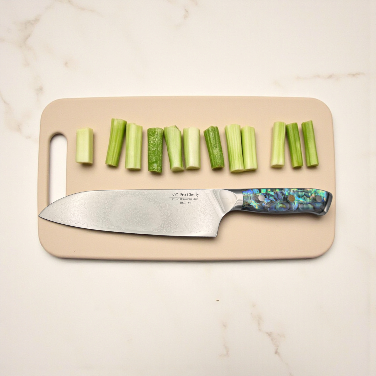 Image of Pro Chefly VG-10 Damascus Santoku Knife with resin handle beside sliced celery on marble countertop.
