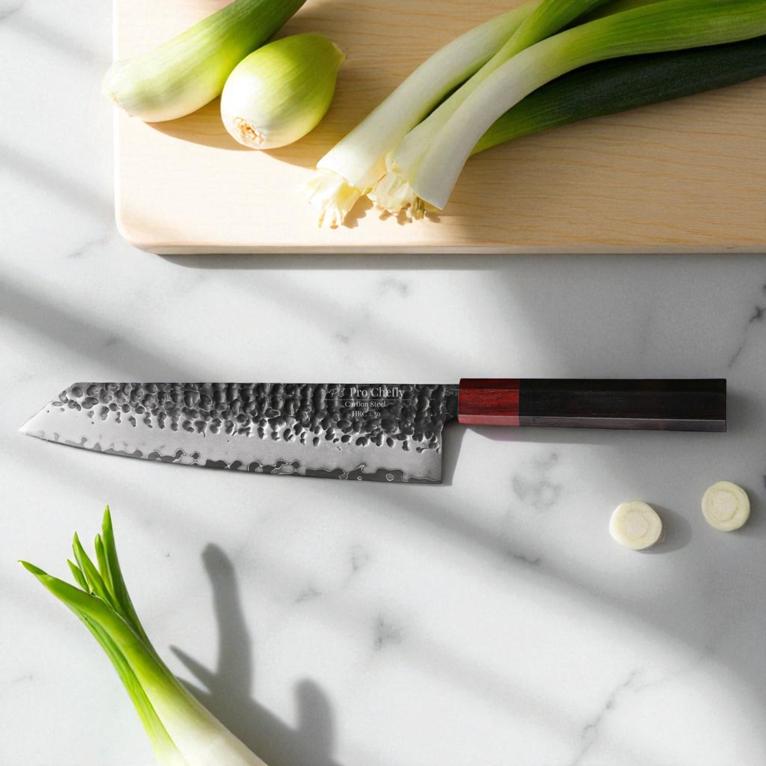 Image of Pro Chefly 3-ply carbon steel Japanese kiritsuke knife with 440C core and pakka wood octagon handle placed on marble beside leeks and spring onions.