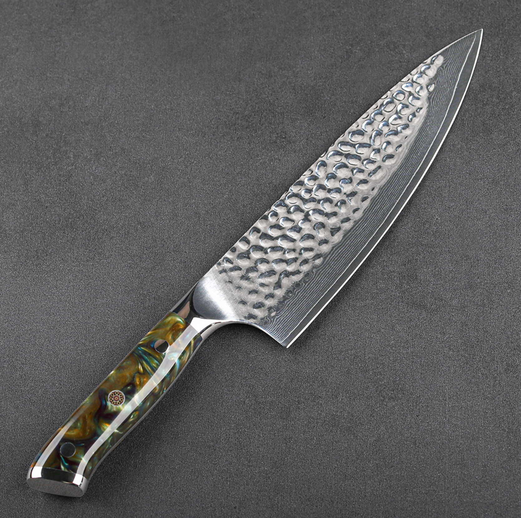 Image of Pro Chefly VG-10 Damascus steel Japanese chef knife with resin handle and hammered Damascus blade laying flat on dark cutting board.
