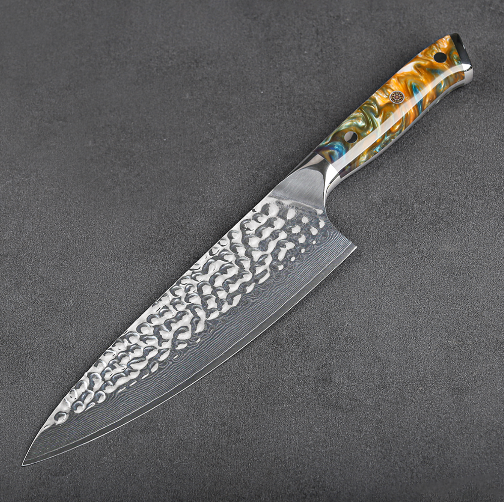 Image of Pro Chefly VG-10 Damascus steel Japanese chef knife with resin handle and hammered Damascus blade angled on dark stone surface.