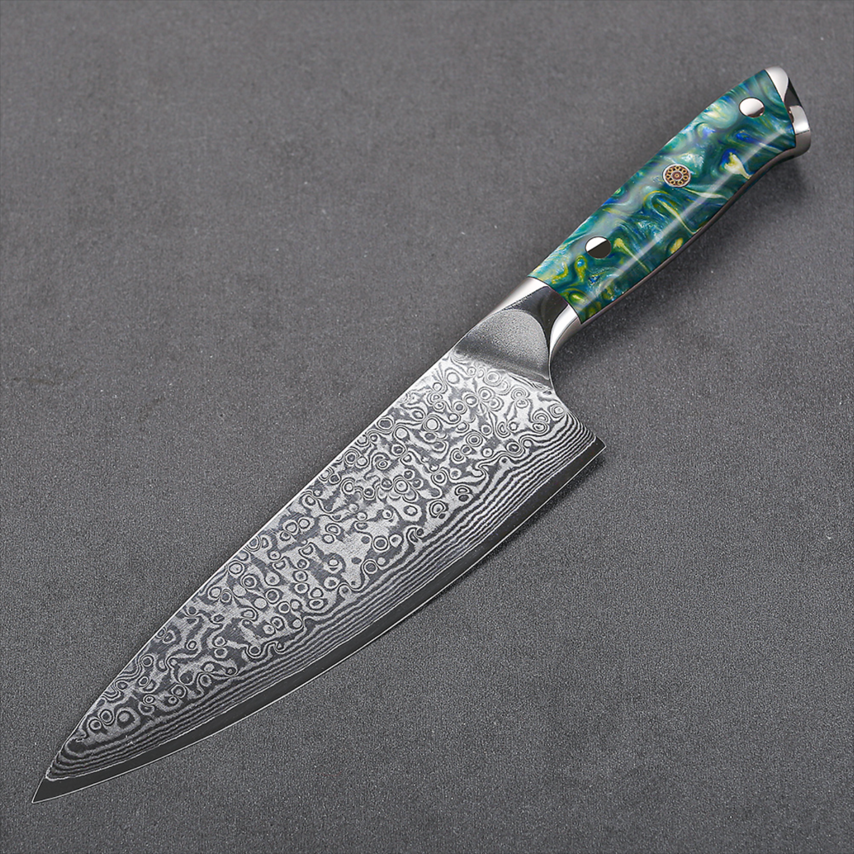 Image of Pro Chefly VG-10 Damascus steel Japanese chef knife with resin handle laying flat on dark surface.