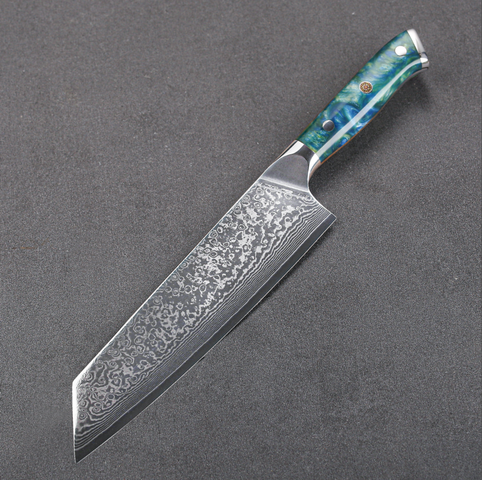 Image of Pro Chefly VG-10 Damascus steel Japanese kiritsuke knife with resin handle positioned on dark surface for detail view.